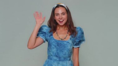 Come here, join us. Welcome. Lovely pretty woman showing inviting gesture with hands, ask to join, beckoning to coming, gesturing hello or goodbye. Adult stylish girl isolated on gray background