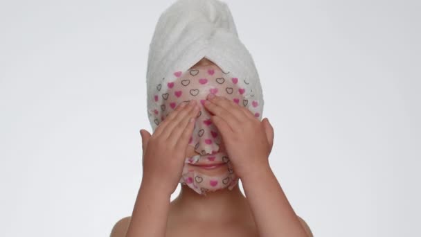 Lovely Young Smiling Child Girl Applying Cosmetic Moisturizing Face Mask — Stockvideo