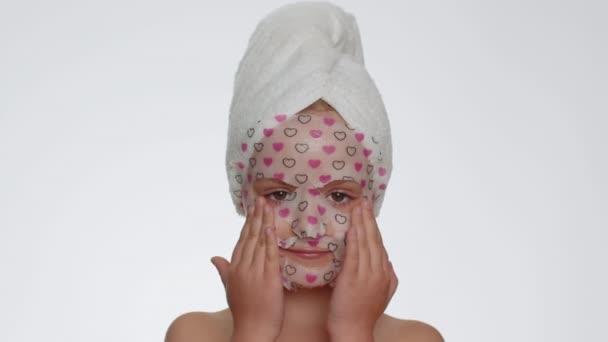 Lovely Young Smiling Child Girl Applying Cosmetic Moisturizing Face Mask — Stockvideo