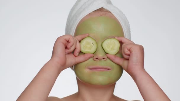 Smiling Child Girl Applying Cleansing Moisturizing Green Facial Mask Holding — Stockvideo