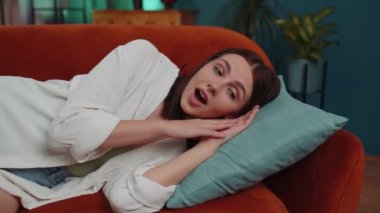 Scared tired caucasian adult girl wakes up from nightmare in bedroom at home. Poor bad sleep of young woman stress, nervousness and anxiety, mental health. Loneliness, sickness, headache concept
