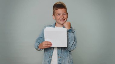 Boy open envelope take out letter reads it feel happy. Career growth advance promotion, bank loan approve, monetary award long-awaited invitation great news. Child isolated on gray studio background