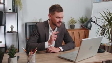 Businessman programmer software developer in suit working on laptop loses becoming surprised sudden lottery results, bad news, fortune loss, fail at office. Concentrated male freelancer business man