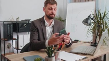 Rich businessman in suit working on smartphone counting money cash, calculate earnings income profit at office workplace. Professional manager freelancer man. Business people. Employment, occupation