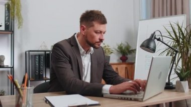 Bored sleepy business man worker working on laptop computer, yawning, leaning on hand falling asleep at office workplace. Exhausted tired freelancer workaholic man. Employment, occupation, workless