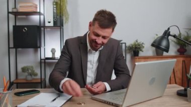 Businessman stock trader earning bitcoins after online monitoring trading operations. Increasing wealth, financial prosperity. Professional freelancer man working on laptop at office workplace desk