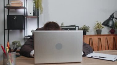 Businessman hiding behind laptop computer, making funny face, fooling around, putting his tongue out remote working disrespecting someone at home office. Male freelancer business man busy occupation