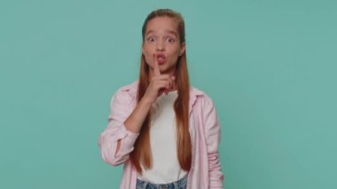 Shh be quiet please. Pretty teenager scared girl presses index finger to lips makes silence gesture sign do not tells secret. Young female child kid isolated alone on blue studio background indoors