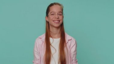 Lovely cheerful pretty teen girl greatly approves your suggestion, shaking head approvely, satisfied with good quality work, like proposal. Young stylish child kid on blue studio background indoors