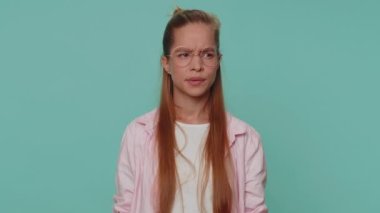 I dont know what to say. Confused pretty teenager young girl feeling embarrassed about ambiguous question, having doubts, no idea, being clueless and uncertain. Student child kid on blue background
