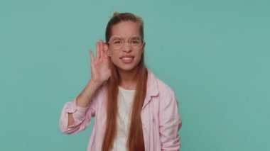 I cant hear you. What. Teen girl trying hear you, looking confused and frowning, keeping arm near ear for louder voice, asking to repeat, to hear information, deafness. Child kid on blue background