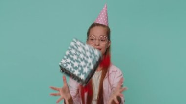 Cheerful lovely pretty teenager girl receiving gift box and smiling joyfully, looking amazed satisfied with nice present, unexpected birthday surprise. Teen female child kid on blue studio background