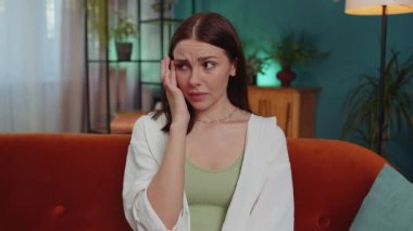 Upset disappointed caucasian young woman wipes tears and cries from despair, being sad because of unfair situation, unrequited love. Problem, break up, depressed feeling bad annoyed, burnout at home