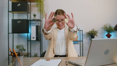Businesswoman stock trader earning bitcoins after online monitoring trading operations. Increasing wealth financial prosperity. Professional freelancer woman working on laptop at office workplace desk