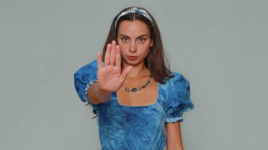 Kes şunu! Genç bir kadın, dur işaretinde el ele tutuşmak yok diyor. Bitiş uyarısı, giriş yasağı, iletişimin kopması, vücut dili, tehlike. Yetişkin kız gri arka planda izole edildi