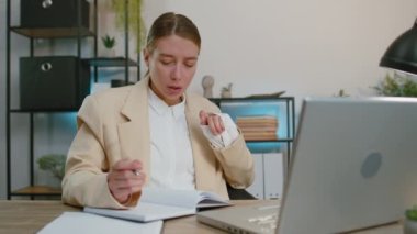 Businesswoman lawyer working on laptop computer online, writing notes in planner notebook at office workplace desk. Professional freelancer student woman. Remote education, study, learning lessons