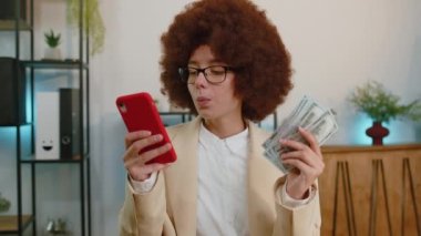Rich business woman working on smartphone counting money cash, calculate earnings income profit at office workplace. Professional manager freelancer girl. Business people. Employment, occupation