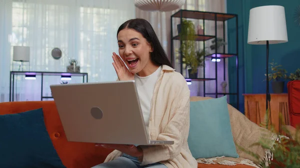 Oh my God Wow. Young woman use laptop computer, receive good news message, shocked by sudden victory, celebrate win, purchases online shopping at home. Modern technologies. Amazed caucasian girl