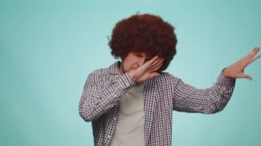 Happy bearded man with lush hair coiffure having fun dancing and moving to rhythm, dabbing raising hands, making dubdance gesture, listening music. Young guy boy celebrating win on blue background