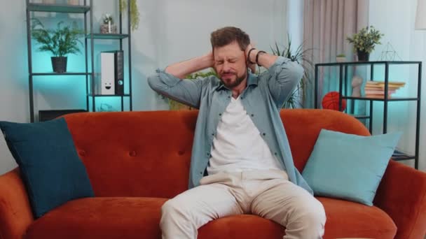 Repair Work Neighbours Concept Irritated Guy Sits Couch Cover Ears — Vídeo de Stock