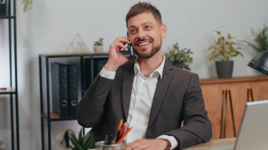 Businessman in suit working, having mobile phone talk at office workplace desk with laptop. Professional manager freelance man holding smartphone using messenger chat apps. Employment, occupation