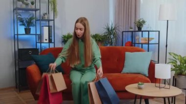 Portrait of caucasian teen girl happy shopaholic consumer came back home after shopping sale with bags. Young child kid satisfied received parcels from online order at home apartment living room