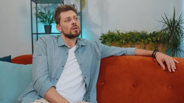 Portrait of sad lonely man lying at home looks pensive thinks over life concerns or unrequited love, suffers from unfair situation. Young guy problem, break up, depressed feeling bad annoyed, burnout