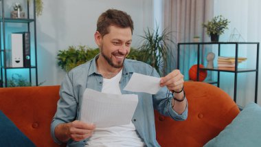 Happy guy open envelope letter, reading it. Career growth advance promotion, bank loan approve, successful admission to university monetary award long-awaited invitation great news, lottery game win