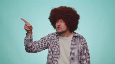 Get out of here. You are fired. Handsome bearded man pointing finger away asking to leave him alone, strict boss firing, conflict. Young adult guy boy isolated alone on blue studio wall background