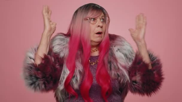 有粉红头发的老年妇女因紧张问题而尖叫 感到恐怖 并表示愤怒 在粉红工作室背景下孤身一人的老祖母 — 图库视频影像