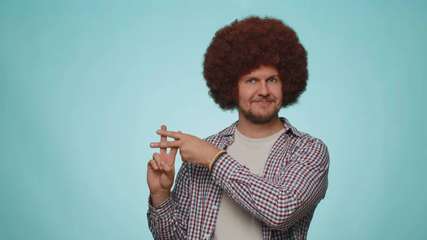 Cheerful bearded man showing hashtag symbol with hands, likes tagged message, popular viral content, sign to follow internet online trends. Young adult guy boy isolated alone on blue studio background