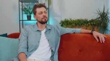 Portrait of sad lonely man lying at home looks pensive thinks over life concerns or unrequited love, suffers from unfair situation. Young guy problem, break up, depressed feeling bad annoyed, burnout