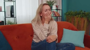 Korkmuş Kafkasyalı kız stres geriliminden bağırıyor panik korku umutsuzluk şaşkınlık şaşkınlık jestler öfke ifade eder. Evdeki kanepede oturan öfkeli, mutsuz genç kadın.