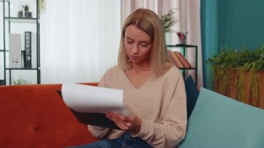 Evrakları okuyan, evde çalışan bir kız. Serbest çalışan bir iş kadını raporları inceliyor. Genç bir kadın maliyetleri, gelirleri, giderleri, proje bütçesini ve mali denetimi hesaplar.