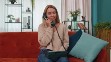 Kız, arkadaşlarıyla telefon görüşmesi yapıyor. Oturma odasında kanepede oturuyorlar. 90 'lı yılların modası geçmiş eski moda telefonlardan konuşan genç bir kadın aptal aptal suratlar yapıyor.