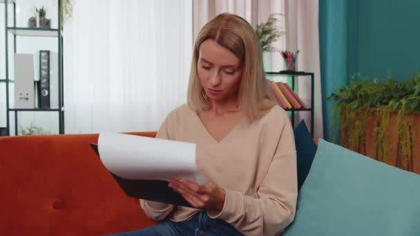 서류읽는 집에서 일하는 프리랜서 사업가가 보고서를 검토하고 여자는 회계사의 조사등을 — 비디오