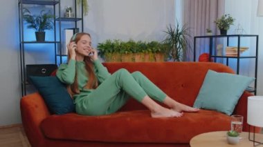 Kablosuz kulaklık takan, evdeki koltukta dinlenen ve en sevilen disko rock n roll müziğini akıllı telefondan dinleyen genç çocuk. İnsanlar hafta sonu aktiviteleri. Neşeli mutlu kız