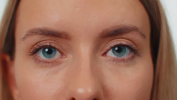 Close-up macro portrait of natural beauty young beautiful womans eyes, smiling looking at camera. Green eyes of woman face, adult pretty girl female model. Lady opening blinking her eyes. Lifestyle