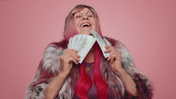 現金お金のドル紙幣のファンを保持幸せなスタイリッシュな女性はダンス 成功のビジネスキャリア 宝くじゲームの勝者 大きな収入 富を祝う ピンクを背景に孤立した高齢者の祖母 — ストック動画