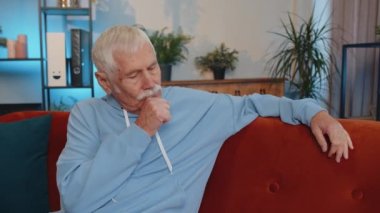 Portrait of sad sick senior old grandfather man at home looks pensive thinks over life concerns or illness, suffers from unfair situation. Problem, break up, depressed feeling bad annoyed, burnout