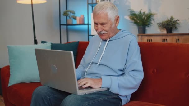 Homem Idoso Muito Feliz Casa Senta Sofá Com Laptop Gritar — Vídeo de Stock