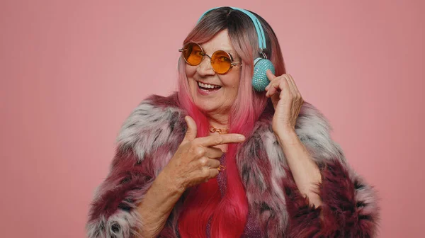 面白い70年代の女性は音楽を聞いて 楽しさを持って リズミカルに彼の手を移動ディスコパーティー音楽にダンス笑顔 勝利を祝うシニア祖母 ピンクの壁の背景に隔離誕生日 — ストック写真
