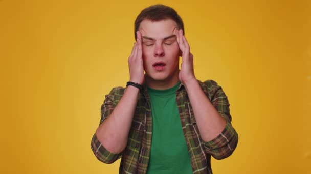 青少年男子穿着衬衫擦拭太阳穴 以治疗头痛 高血压等症状 这些症状在黄墙背景下单独存在 — 图库视频影像