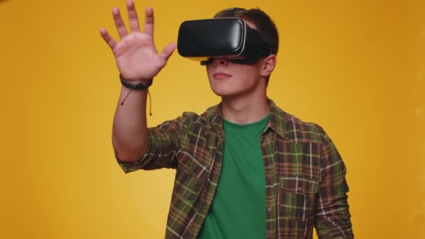 シミュレーション3D 360ビデオゲーム 描画を再生するために仮想現実未来技術Vrアプリヘッドセットヘルメットを使用してスタイリッシュな男を追放 黄色のスタジオの背景に若い大人の男の子 人々の誠実な感情 — ストック動画