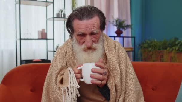 소파에서 추위에 추위에 할아버지가 고온화 아파트에서 뜨거운 마시고 건강하지 할아버지는 — 비디오
