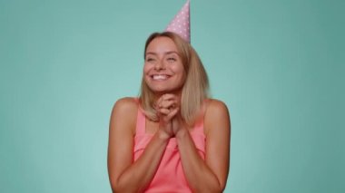 Neşeli genç kadın hediye kutusunu açıyor, doğum günü sürprizini açıyor ve en iyi hediye ikramiyesiyle tatmin olmuş bir şekilde büyük bir mutluluk hayretini dile getiriyor. Güzel kız stüdyo mavisi arka planda tek başına.