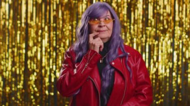 Evreka. 70 'li yaşlarda, ağzı açık, Eureka jesti, çözümü, fikri, ilhamı, cevabı gösteren ceketli bir kadın. Parlak disko partisinin arka planında yaşlı bir büyükanne yalnız.