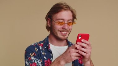 Happy excited joyful man in casual shirt use mobile cell phone typing browsing shouting say wow yes found out great big win, good news, lottery goal achievemen, celebrating success, winning