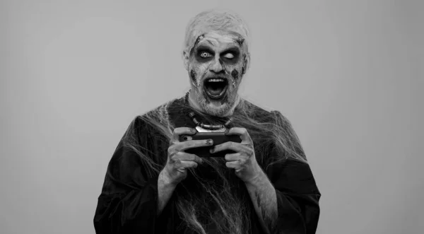 무서운 할로윈 비분장을 남자가 핸드폰으로 레이싱 비디오 게임을 열광했습니다 온몸에 — 스톡 사진