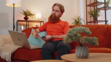 Planlama bütçesi. Zengin ve mutlu bir adam nakit para sayıyor dizüstü bilgisayar hesap makinesi kullanıyor ve evdeki faturaları hesaplıyor. Gelirimden tatmin olan genç adam, kazanç, planlı tatil için para biriktirmek, hediyeler.